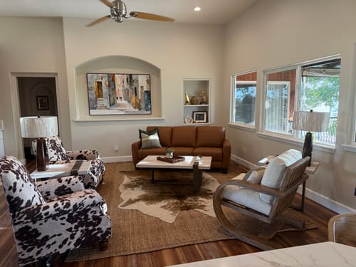 Customer's Textured Alley Scene painting hanging in an arched alcove above a sofa in their living room.